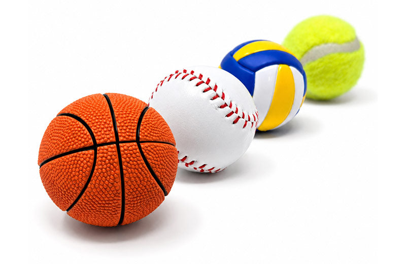 Basketball, baseball, volleyball and tennis ball in a lineup.